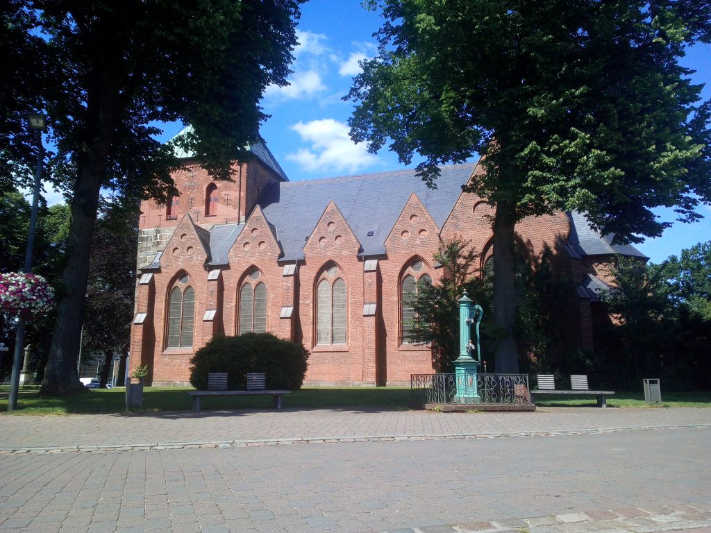 Nortorf St. Martin Kirche, Bäume und die Kirche im Hintergrund.